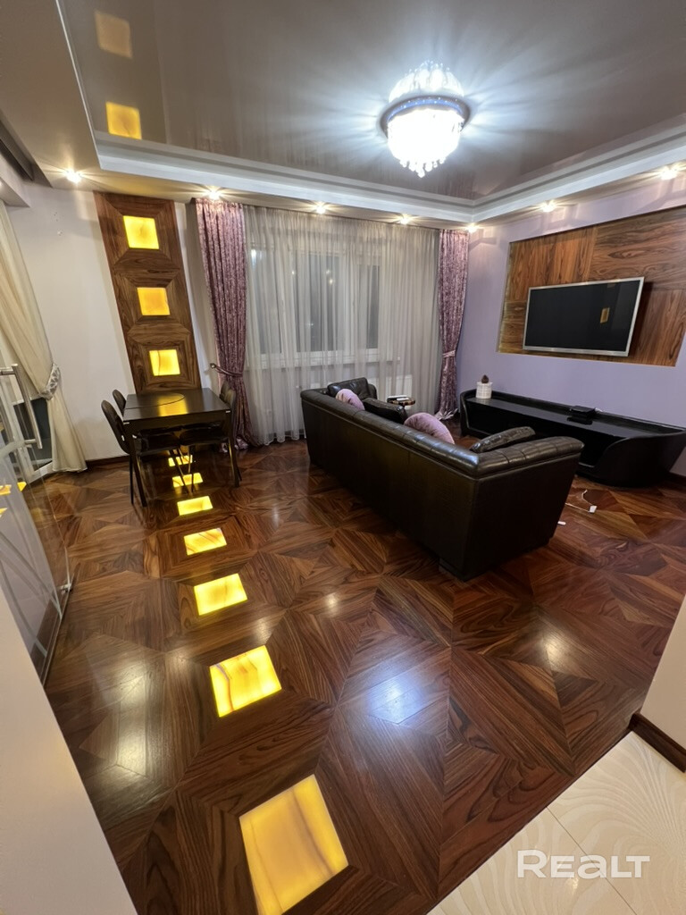 Сдаётся премиальная 3-комнатная квартира 90 м² на 15 этаже в 5 минутах от центра Минска с панорамным видом на город. Свежий дизайнерский ремонт, просторная кухня-гостиная, 2 утеплённые лоджии, гардеробная и много мест хранения. Паркет из натурального дерева, 2 санузла с джакузи и биде. Полностью укомплектована премиальной техникой: кондиционеры, Smart TV, посудомойка, стирально-сушильная машина, тёплые полы, Wi-Fi. Отапливаемый индивидуальный паркинг включён. - Widok 5