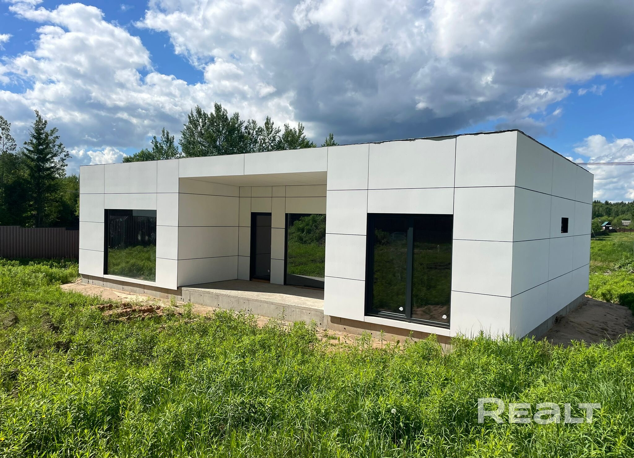 Дом расположен в закрытом коттеджном поселке в 13 км от Минска. Московское направление, центр.коммуникации, вода, электричество 25 квт, три фазы введено в дом, заезд в поселок с авто-воротами и видеонаблюдением. Дом построен по технологии Prefab, заводского производства премиум качества. Большие панорамные окна с закаленными стеклами. Двери и окна дерево алюминий. Планируется введение газа в поселок и присоединение к деревне.Есть проект дома. поможем с отделкой, рядом остановка, река Волма 4км – pohled 3