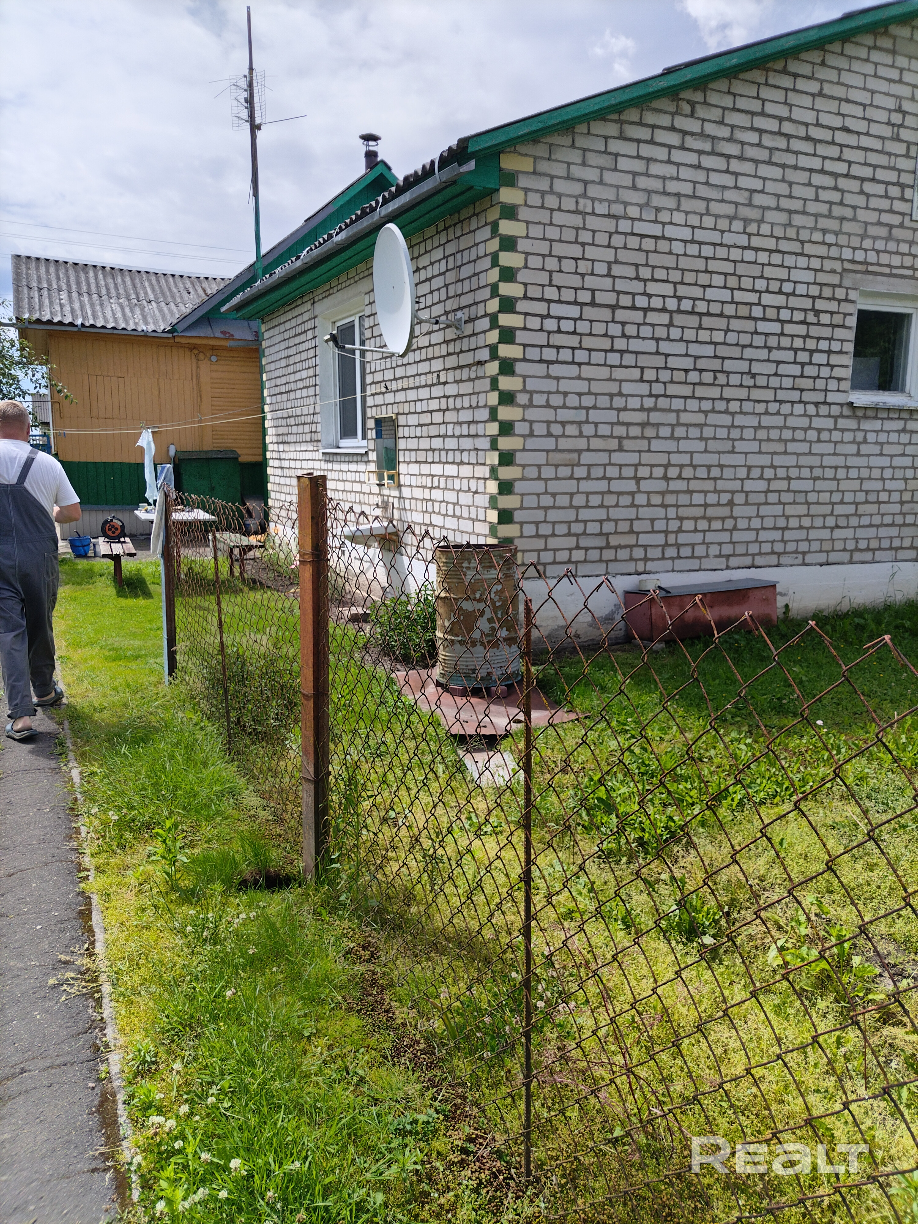Дом состоит из одноэтажного бревенчатого жилого помещения, двух кирпичных жилых пристроек и дощатой веранды. Участок еще включает две бревенчатые хозпостройки, дворовой погреб, два кирпичных гаража, один из которых имеет смотровую яму.Есть двухконтурный газовый котёл, резерв - твёрдотопливный газовый котел. Есть печь с лежанкой и в одной из комнат— групка(стояк). По улице проведена центральная канализация, с возможностью подключения к ней. Улица асфальтированная. - Aanzicht 5
