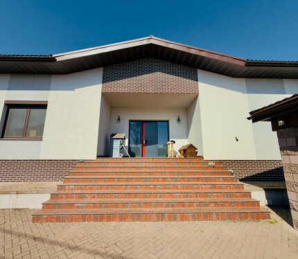 Сдается современный дом с дизайнерским ремонтом всего в 1 минуте от МКАД. В доме просторная гостиная с панорамными окнами, большая кухня с островом и встроенной техникой, несколько спален, гардеробная, ТВ-комната и постирочная. 2 санузла: душевая и ванная комната с джакузи. Дом полностью меблирован и готов к проживанию. Дизайнерские потолки с LED-подсветкой, современный ремонт и много света. Участок огорожен, есть навес для автомобиля. Отличный вариант для комфортной жизни рядом с городом.